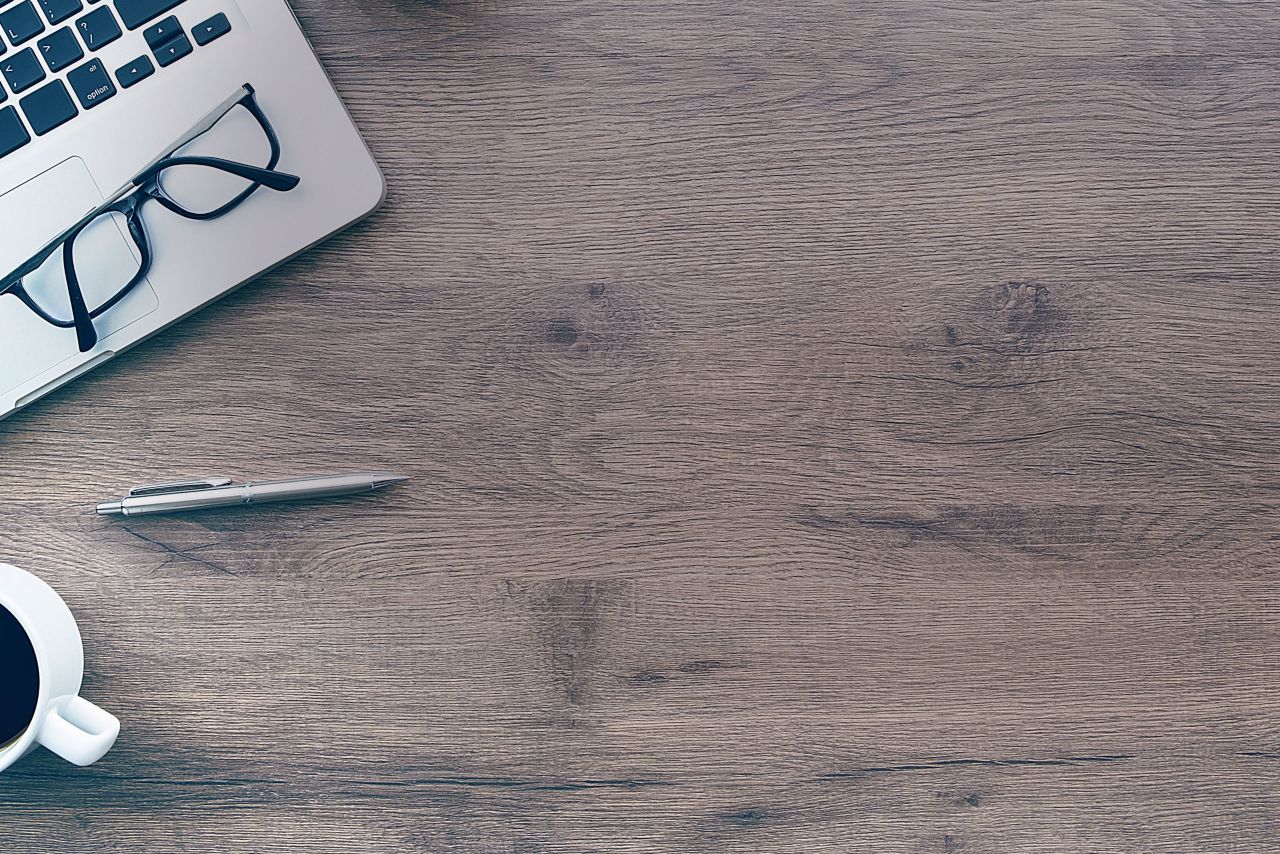 Schreibtisch mit Notebook und Kaffeetasse
